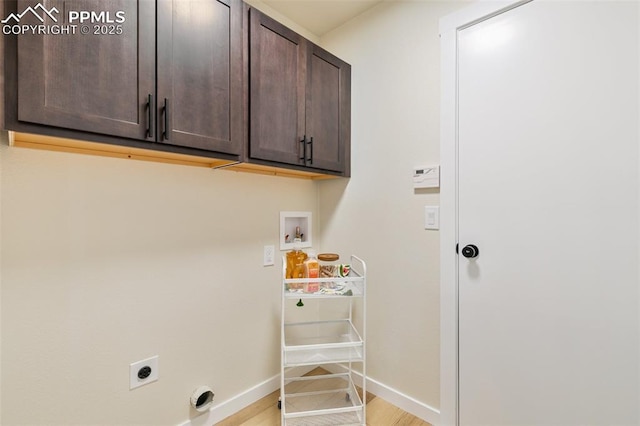 washroom with hookup for a washing machine, cabinets, light hardwood / wood-style flooring, and electric dryer hookup