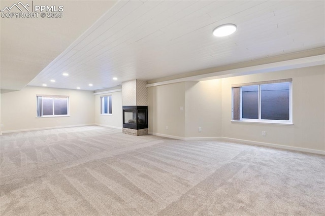 unfurnished living room featuring light carpet and a multi sided fireplace