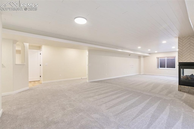 basement featuring a multi sided fireplace and light carpet