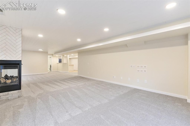 basement with a multi sided fireplace and light colored carpet