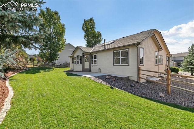 back of property with a lawn and a patio