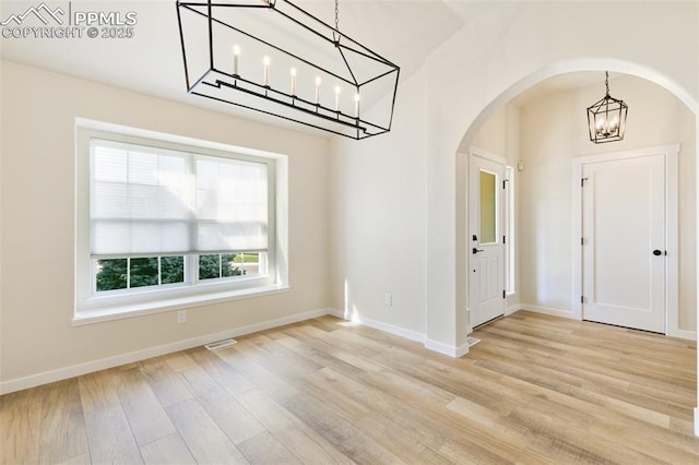 entryway featuring light hardwood / wood-style floors and an inviting chandelier