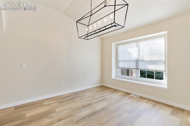 unfurnished dining area with lofted ceiling and light hardwood / wood-style flooring