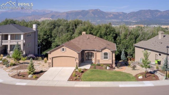 view of front of property featuring a front yard, a garage, and a mountain view