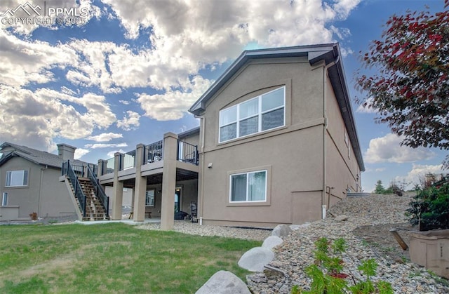 back of property with a yard and a wooden deck