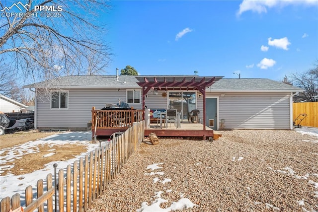 snow covered back of property featuring a pergola and a wooden deck