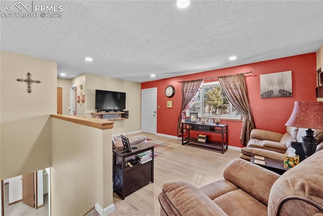 living room featuring light wood-type flooring and a textured ceiling