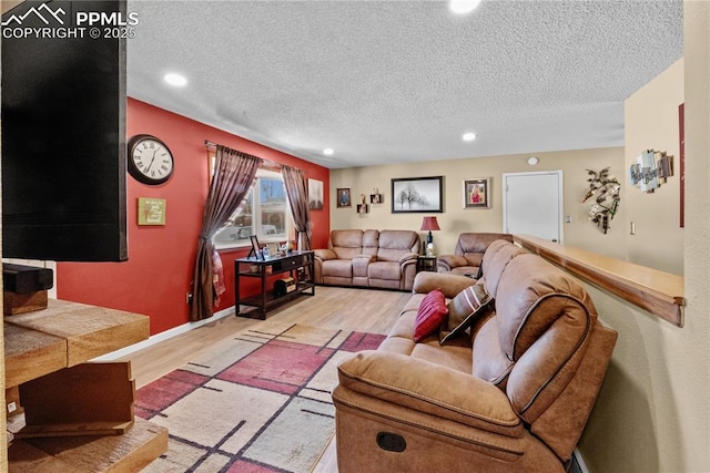 living room featuring a textured ceiling and light hardwood / wood-style floors