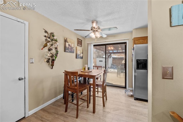 dining space with ceiling fan, a textured ceiling, and light hardwood / wood-style flooring