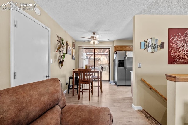 dining space with a textured ceiling, ceiling fan, and light hardwood / wood-style floors