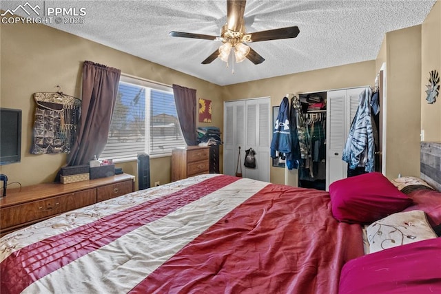 bedroom featuring a textured ceiling, multiple closets, and ceiling fan