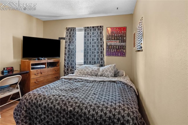 bedroom featuring a textured ceiling and hardwood / wood-style floors