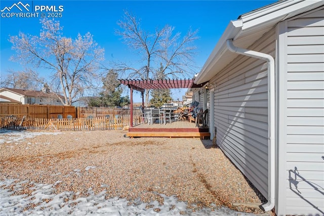 yard layered in snow with a pergola and a deck