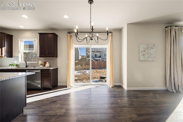 kitchen featuring pendant lighting, stainless steel dishwasher, dark brown cabinetry, and an inviting chandelier