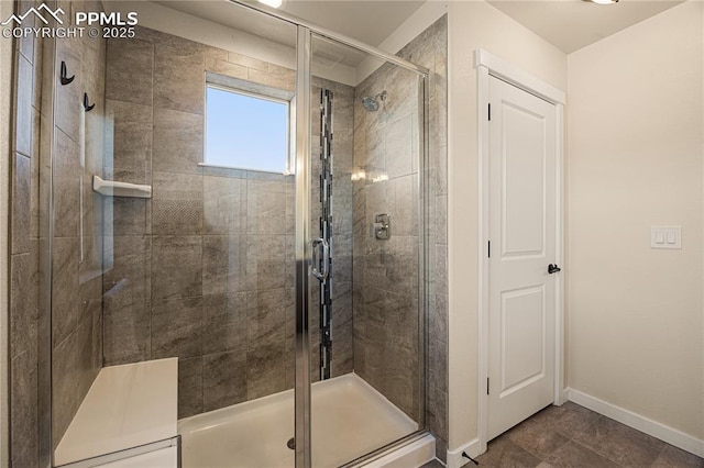 bathroom with a shower with shower door and tile patterned flooring