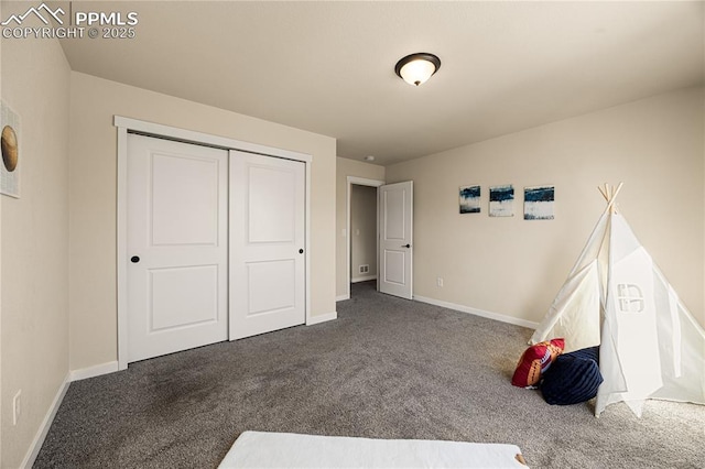 unfurnished bedroom featuring a closet and dark colored carpet