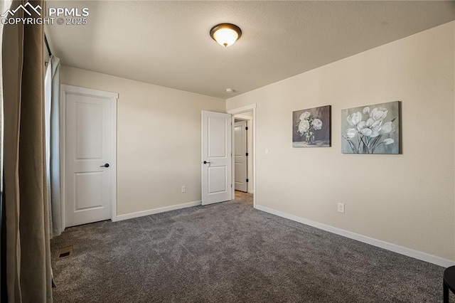 unfurnished bedroom with dark carpet