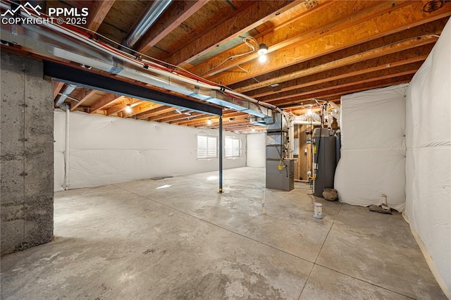 basement featuring heating unit and water heater