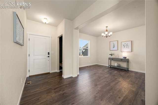 foyer entrance with dark hardwood / wood-style floors and a chandelier