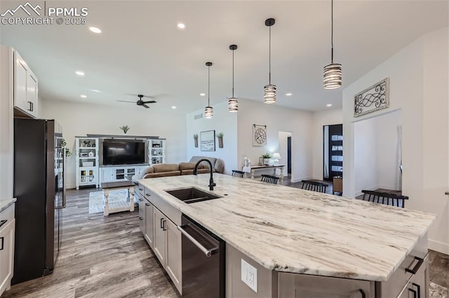 kitchen with sink, stainless steel dishwasher, white cabinets, and black refrigerator