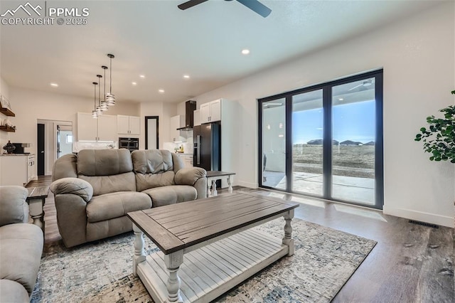 living room featuring hardwood / wood-style floors and ceiling fan