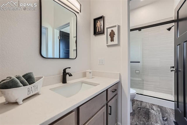 bathroom with vanity, a shower with shower door, and toilet