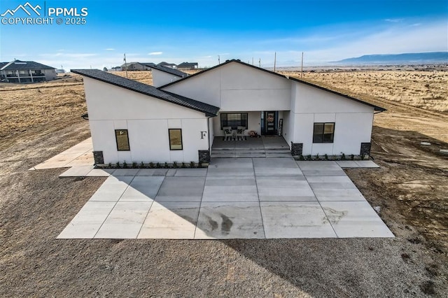 view of front of home with a mountain view and a patio