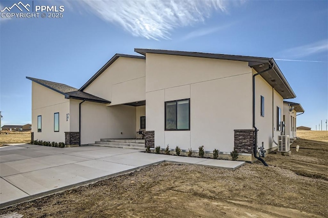 rear view of property featuring a patio and cooling unit