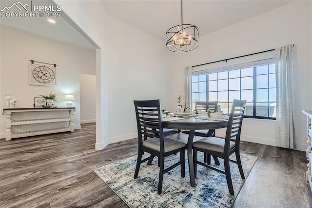 dining area with dark hardwood / wood-style floors and a notable chandelier