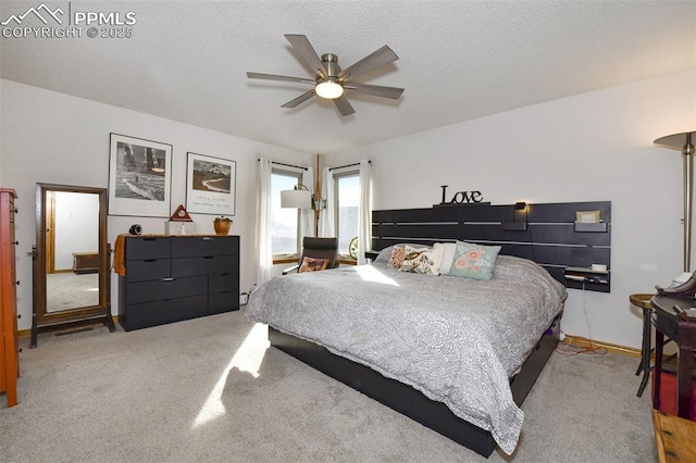 bedroom featuring ceiling fan, light colored carpet, and a textured ceiling