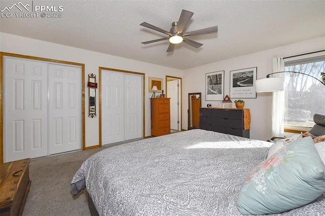 bedroom featuring ceiling fan, two closets, carpet, and a textured ceiling