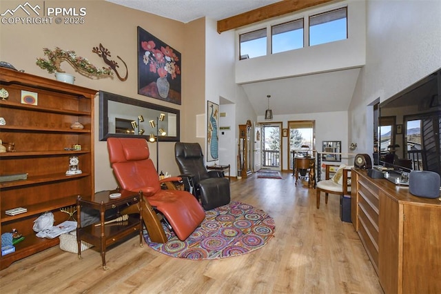 interior space with a high ceiling, light hardwood / wood-style floors, and beamed ceiling