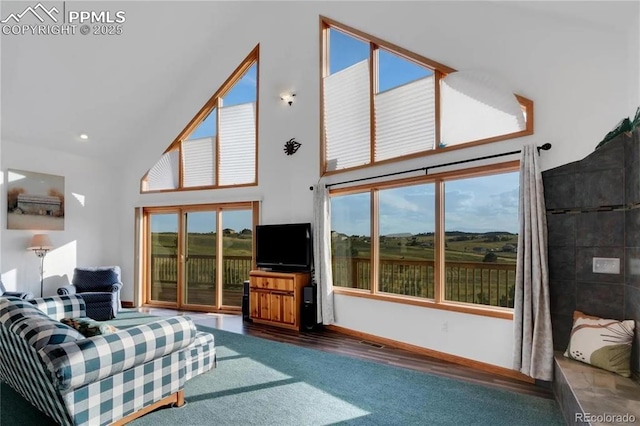 living room with high vaulted ceiling and dark colored carpet