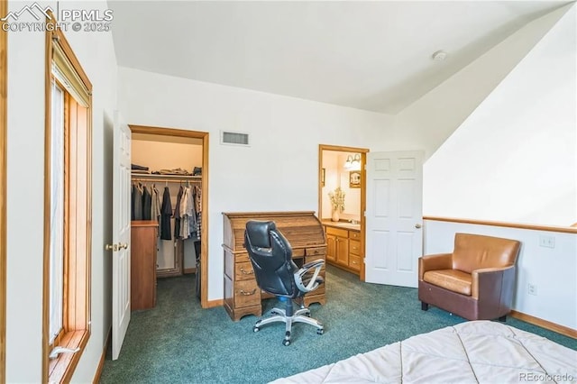 bedroom featuring a walk in closet, lofted ceiling, dark carpet, and a closet