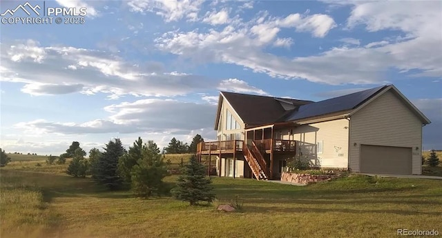 view of side of home with a garage, a deck, and a lawn