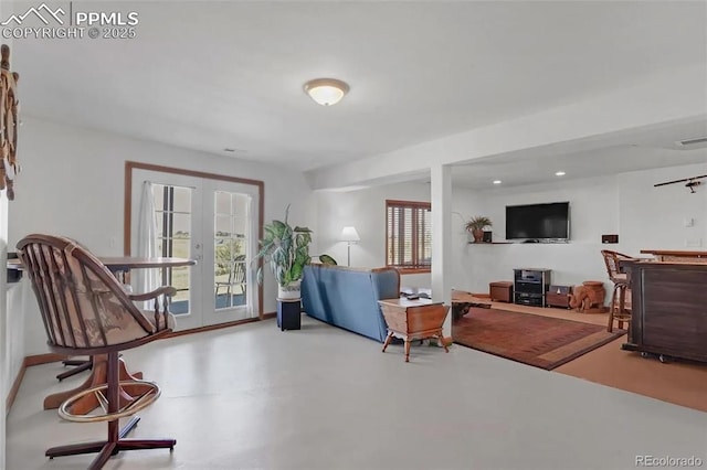 living room featuring french doors and concrete floors