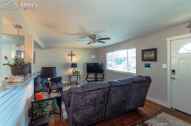 living room featuring plenty of natural light, dark wood-type flooring, and ceiling fan