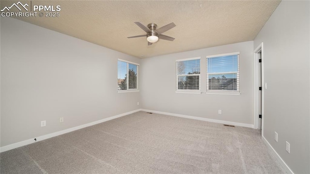 unfurnished room featuring ceiling fan, light colored carpet, and a textured ceiling