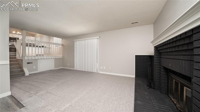 unfurnished living room featuring a textured ceiling, a brick fireplace, and carpet floors