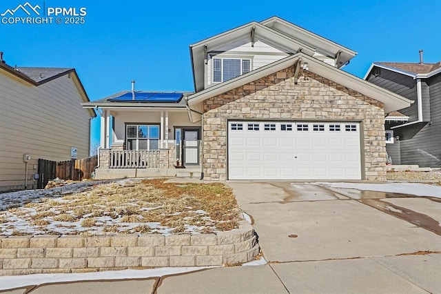 view of front of house with covered porch, a garage, and solar panels