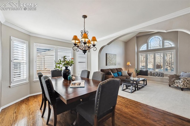 dining room with an inviting chandelier, wood-type flooring, and ornamental molding