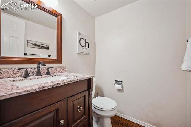 bathroom featuring vanity, hardwood / wood-style flooring, and toilet