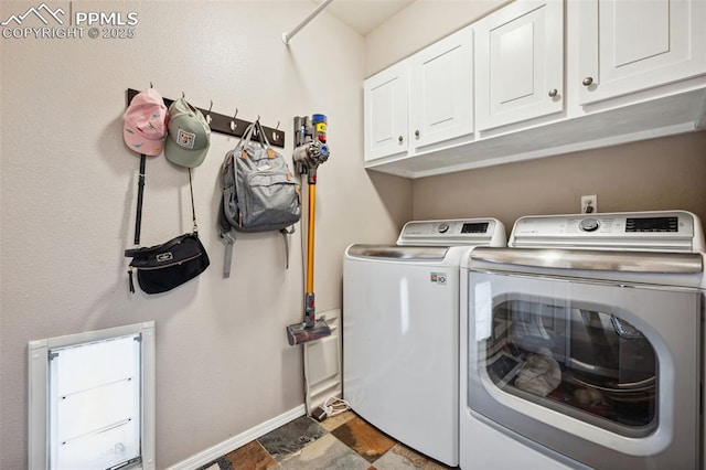 washroom with washer and dryer and cabinets