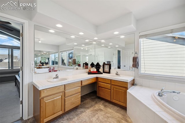 bathroom featuring vanity and a relaxing tiled tub