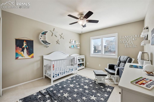 bedroom featuring a nursery area, ceiling fan, and carpet