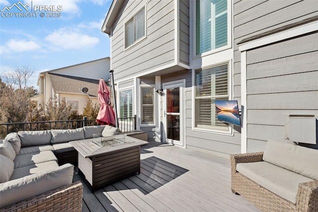 deck with an outdoor living space with a fire pit