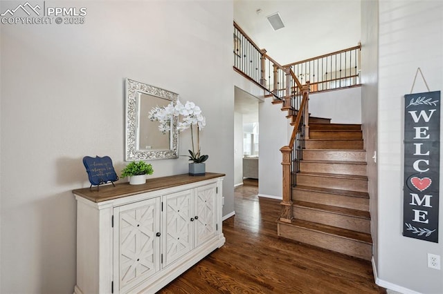 staircase featuring a high ceiling and hardwood / wood-style floors