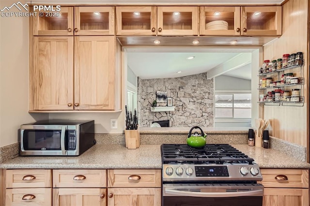 kitchen featuring vaulted ceiling, appliances with stainless steel finishes, and light brown cabinetry