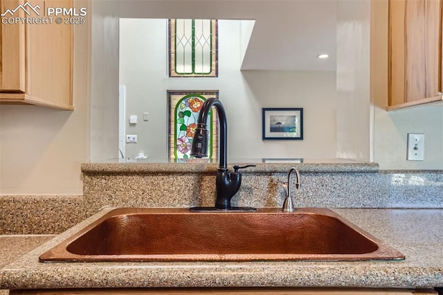 room details featuring light stone countertops, sink, and light brown cabinets