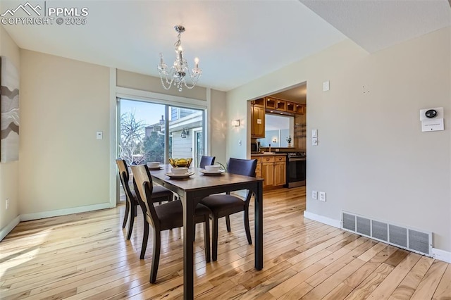 dining room with light hardwood / wood-style flooring and a chandelier